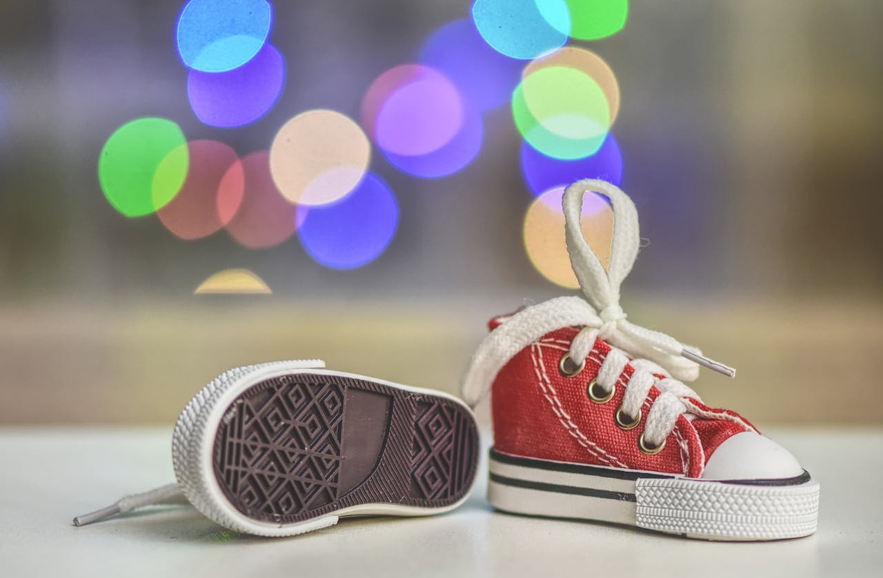Charming red baby sneakers on a bokeh background, highlighting cute footwear design.